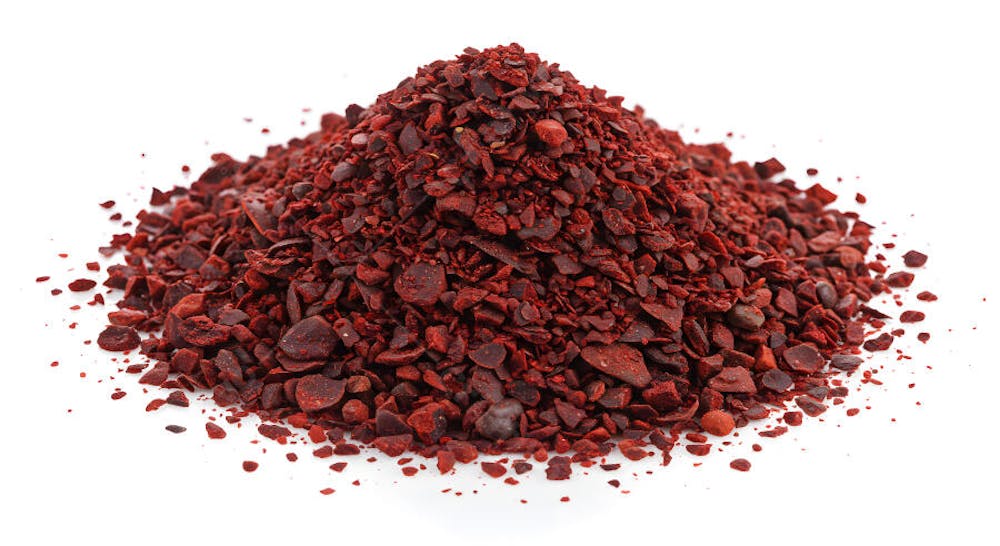 Pilha de especiarias de sumagre vermelho em fundo branco