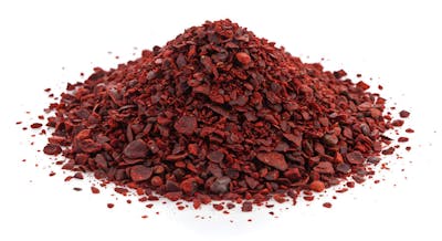 Pilha de especiarias de sumagre vermelho em fundo branco