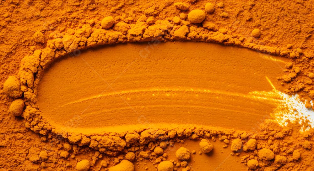 Pó de cúrcuma laranja vibrante com gotas líquidas