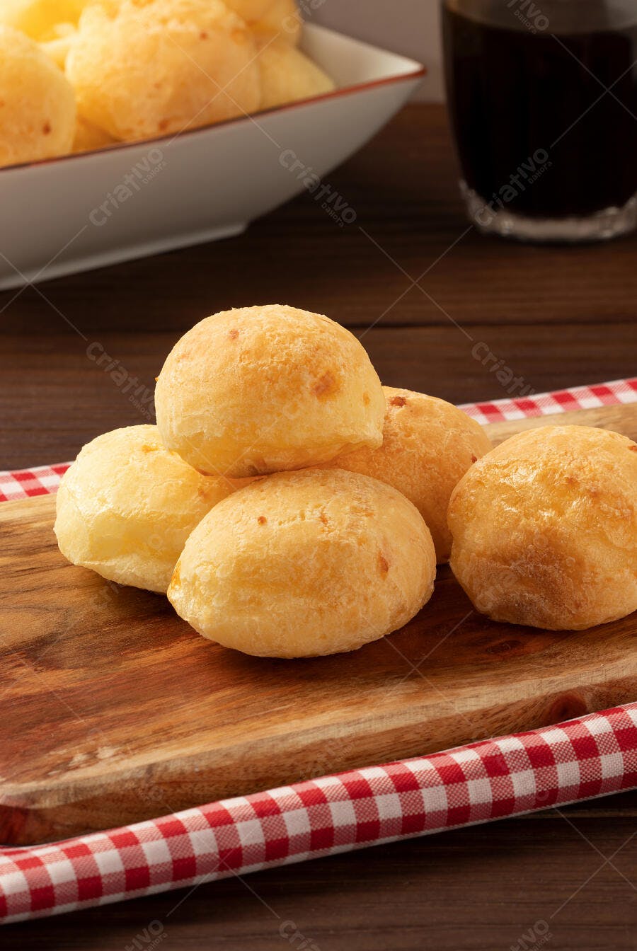 Pãezinhos de queijo deliciosos em tábua de madeira