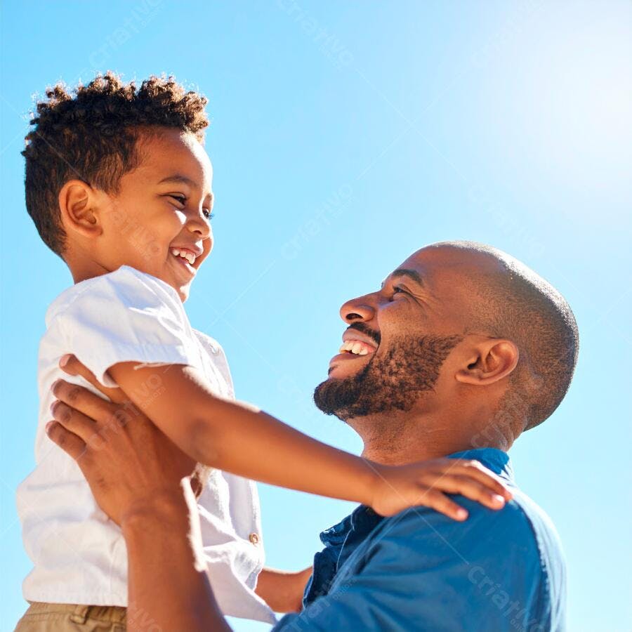 Pai e filho negros rindo ao ar livre