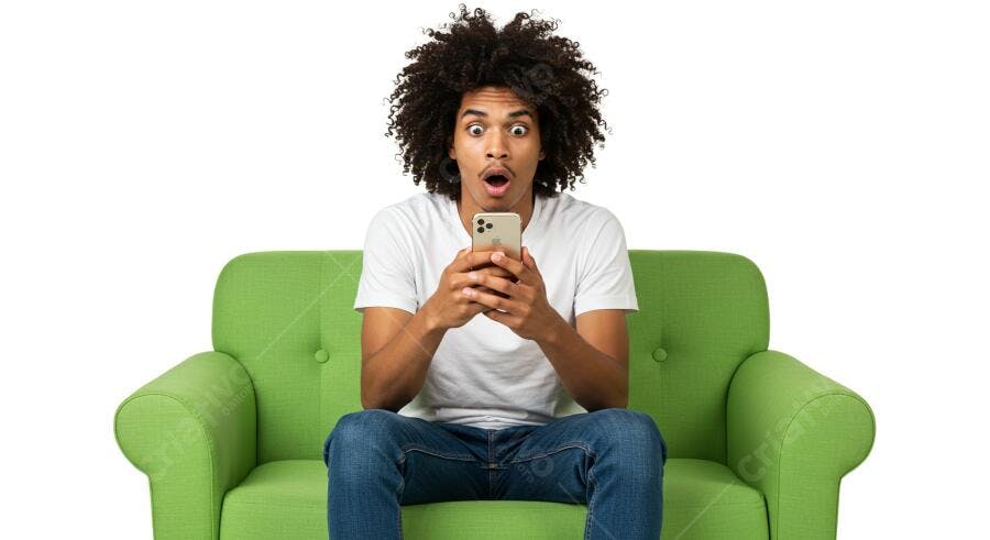 Homem surpreso usando celular sofá verde