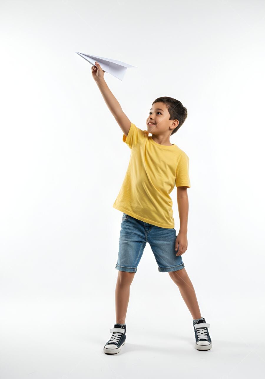 Menino feliz lançando aviãozinho de papel