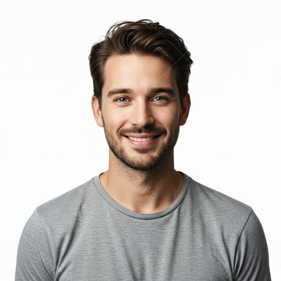 Homem jovem caucasiano sorrindo com olhos azuis e camiseta cinza em fundo branco