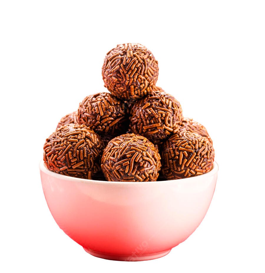 Brigadeiros de chocolate com granulado em tigela rosa claro fundo branco