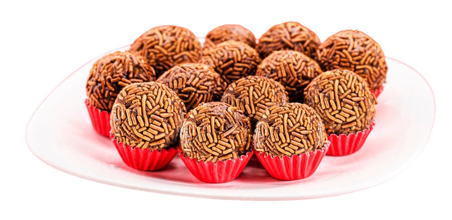 Brigadeiros de chocolate com granulados em forminhas vermelhas