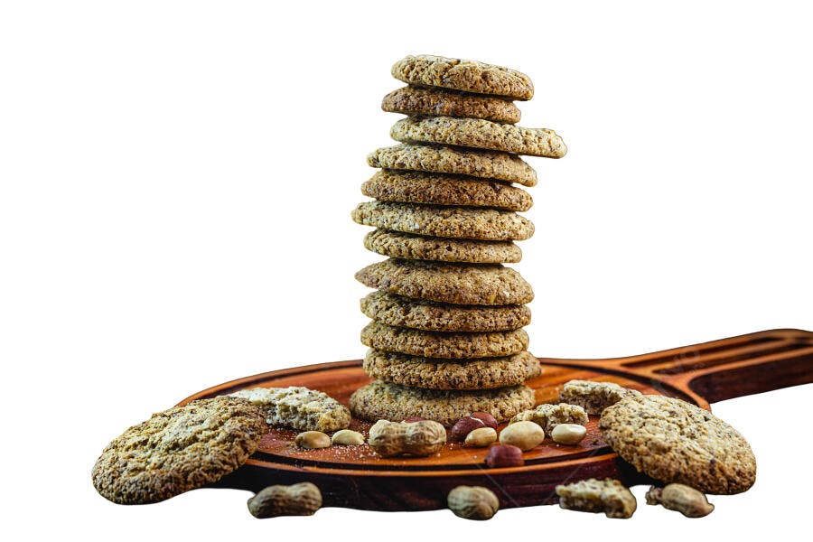 Pilha de biscoitos integrais de aveia com amendoins em tábua de madeira