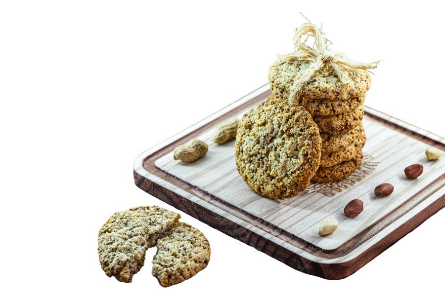 Biscoitos de aveia e amendoim empilhados com barbante em tábua de madeira