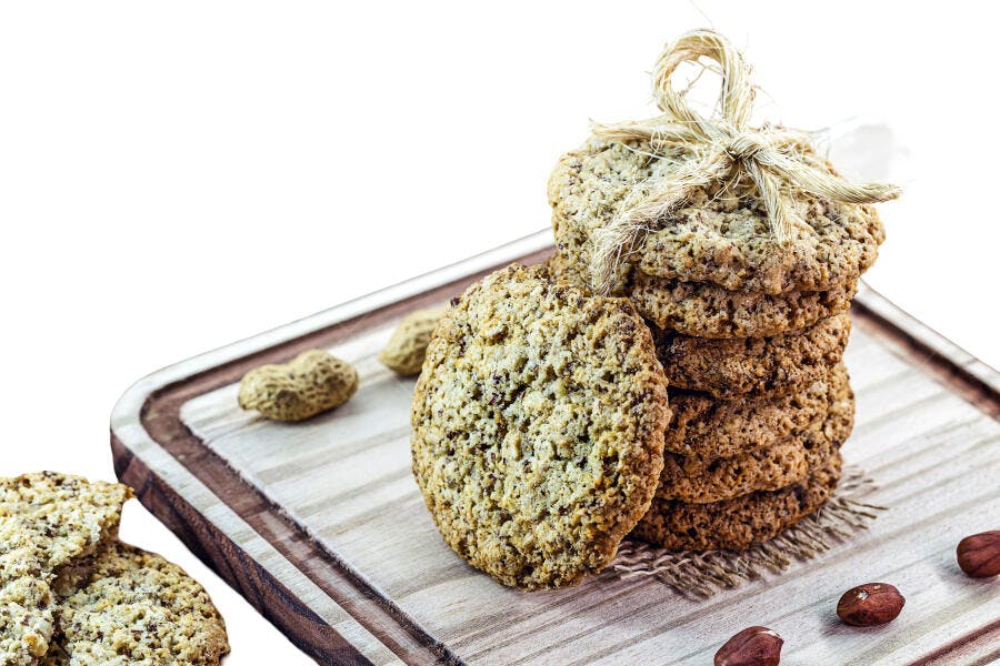 Biscoitos de amendoim e aveia empilhados em tábua de madeira rústica