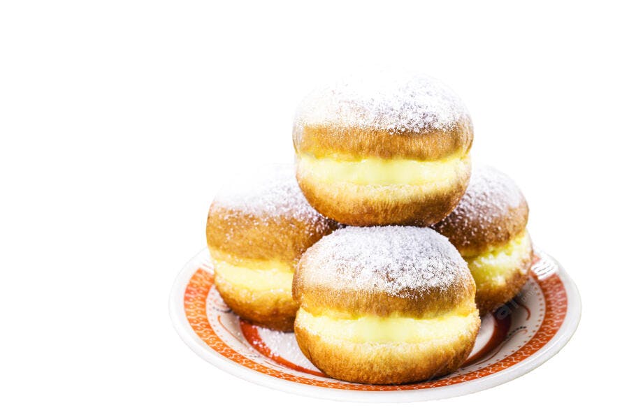 Sonhos de padaria recheados com creme e açúcar de confeiteiro em prato