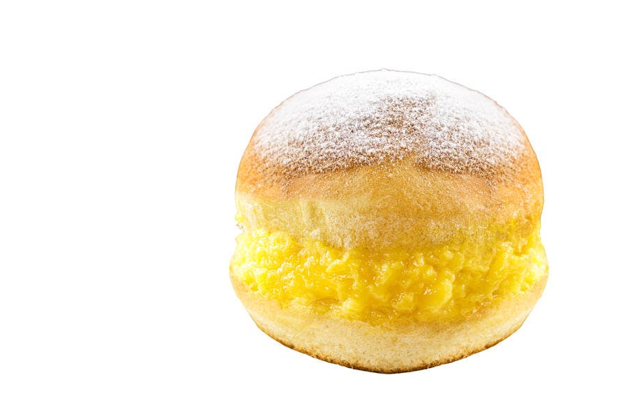 Sonho recheado com creme amarelo e açúcar de confeiteiro em fundo branco