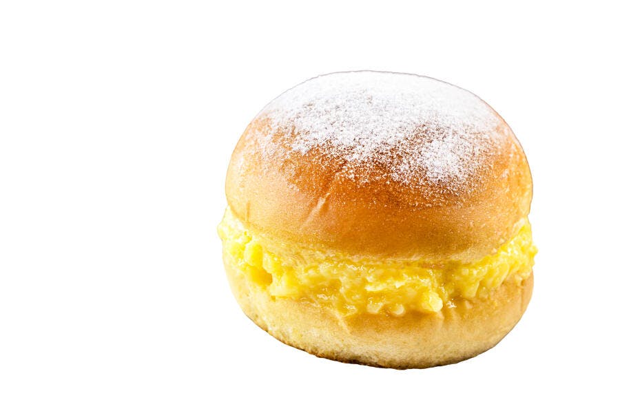 Sonho brasileiro com recheio de creme e açúcar de confeiteiro isolado