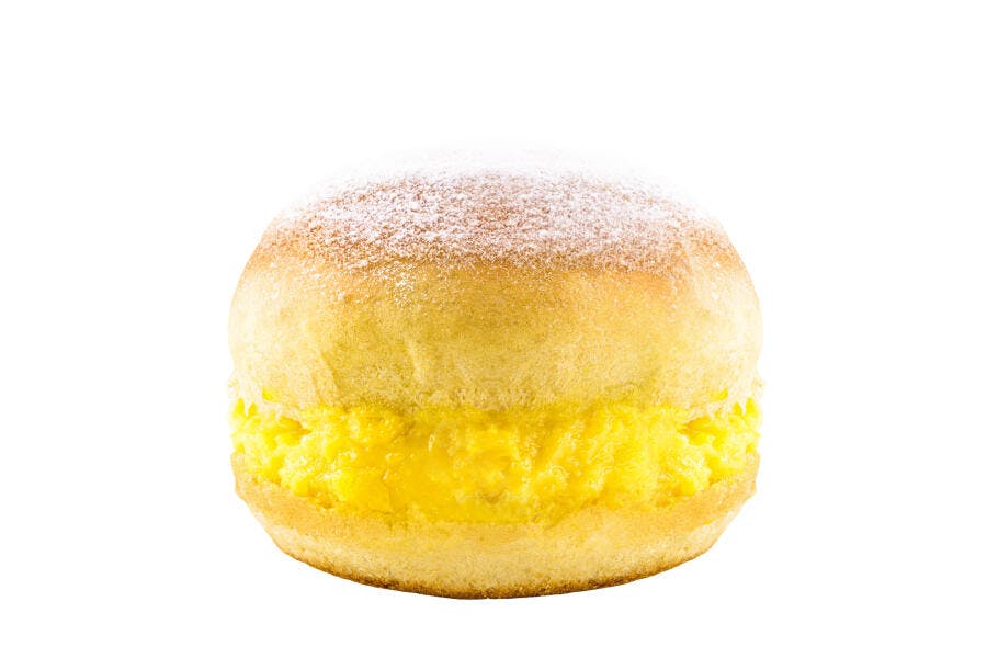 Sonho de creme amarelo doce com açúcar de confeiteiro