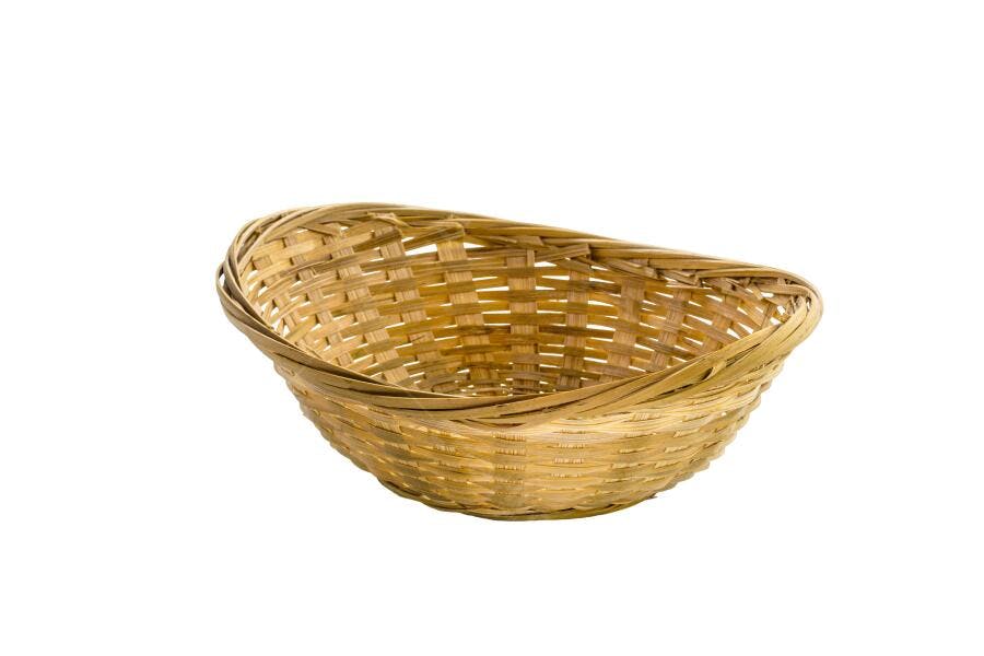 Cesta de vime oval em tons de bambu claro isolada em fundo branco