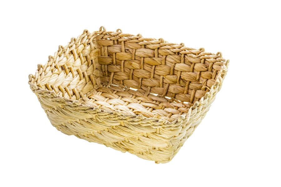 Cesta quadrada de palha tecida artesanalmente em fundo branco isolado