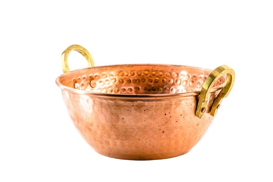 Tacho de cobre martelado com alças douradas em fundo branco isolado