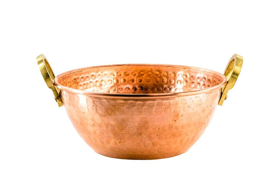 Tigela de cobre martelada com alças douradas em fundo branco