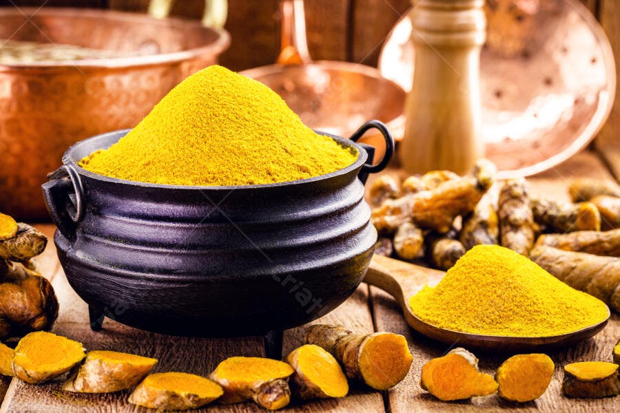 Açafrão da terra pó amarelo vibrante e raízes frescas em panela rústica