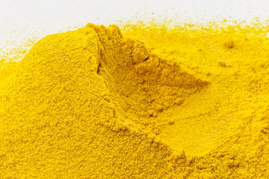 Cúrcuma em pó amarelo vibrante montanha em fundo branco