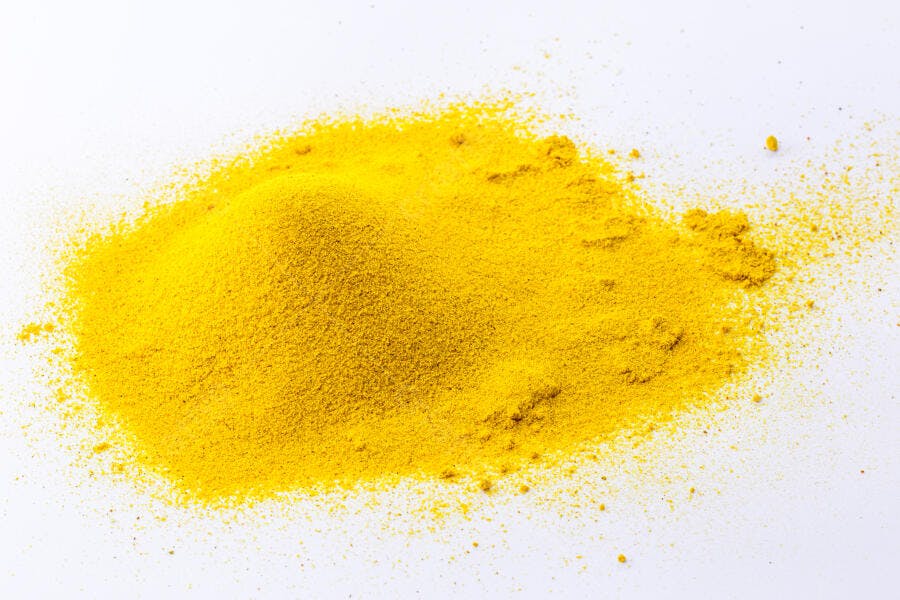 Pó amarelo de cúrcuma especiaria em montinho sobre fundo branco