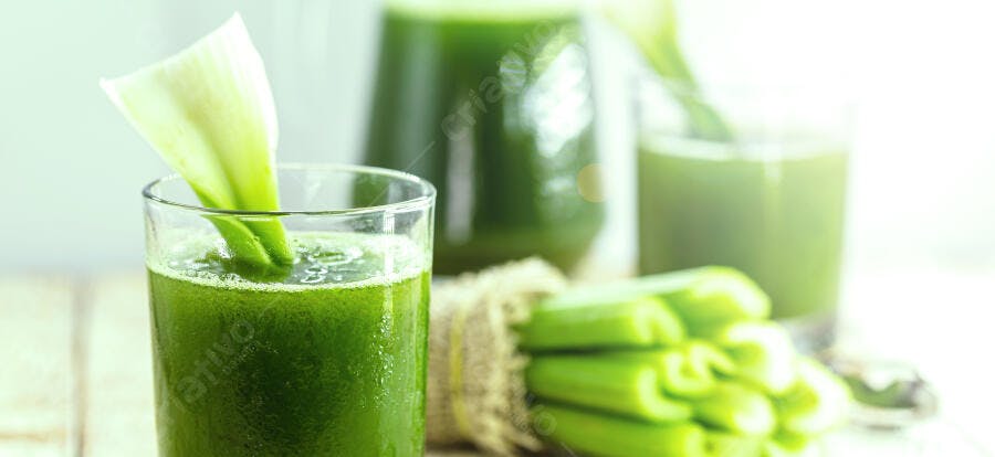 Suco de aipo verde vibrante fresco com talo de aipo no copo