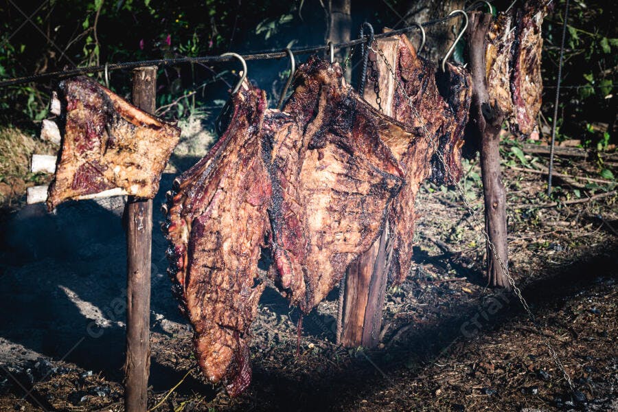 Carne de costela assada no fogo de chão em churrasco tradicional ao ar livre