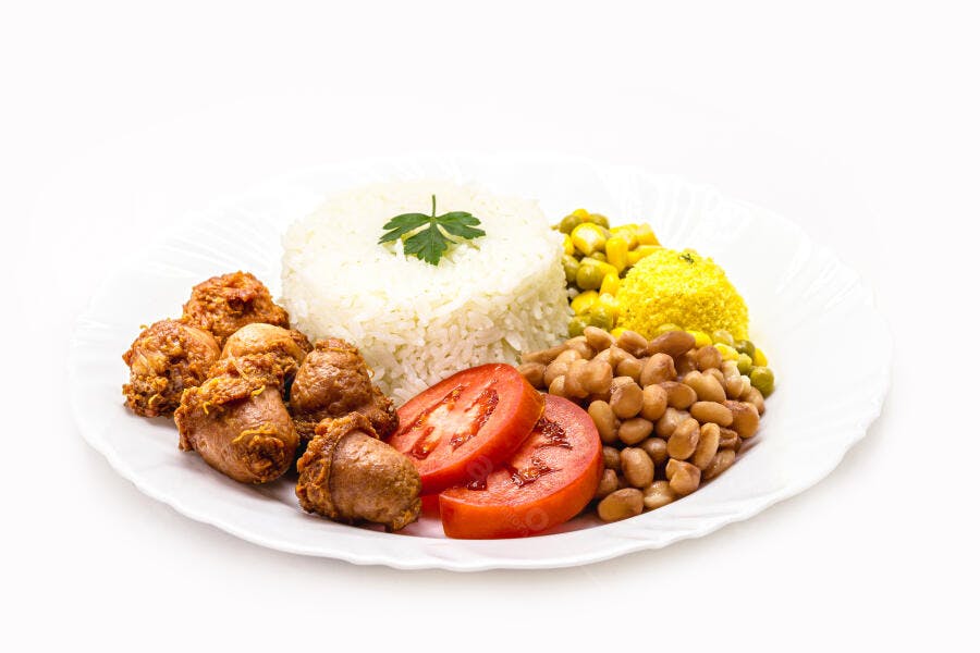 Prato de comida brasileira com frango frito, arroz, feijão, tomate e farofa em fundo branco