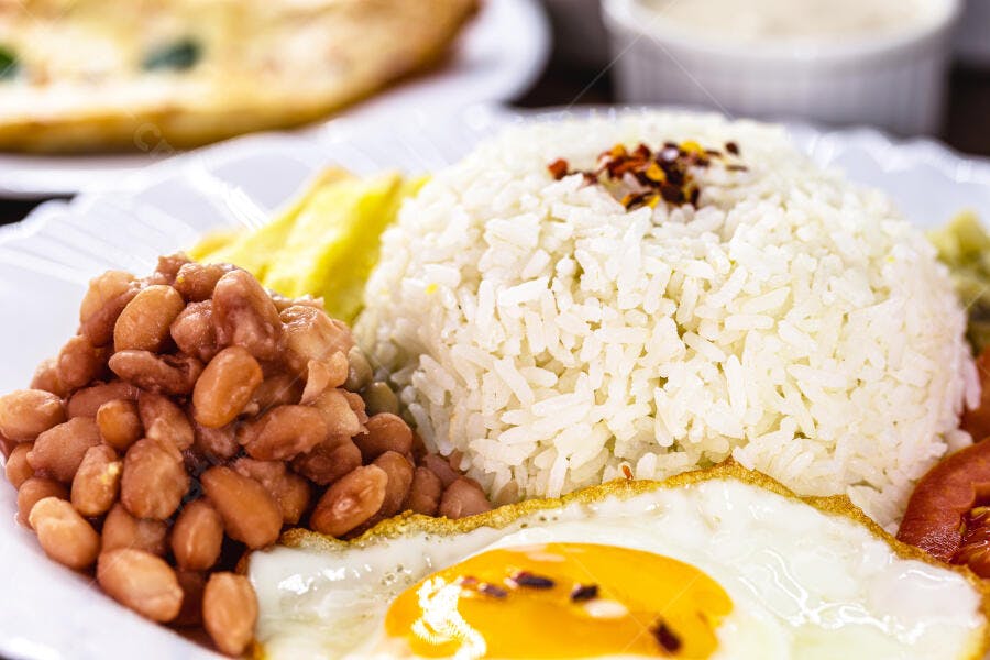 Prato brasileiro arroz branco, feijão, ovo frito e banana frita