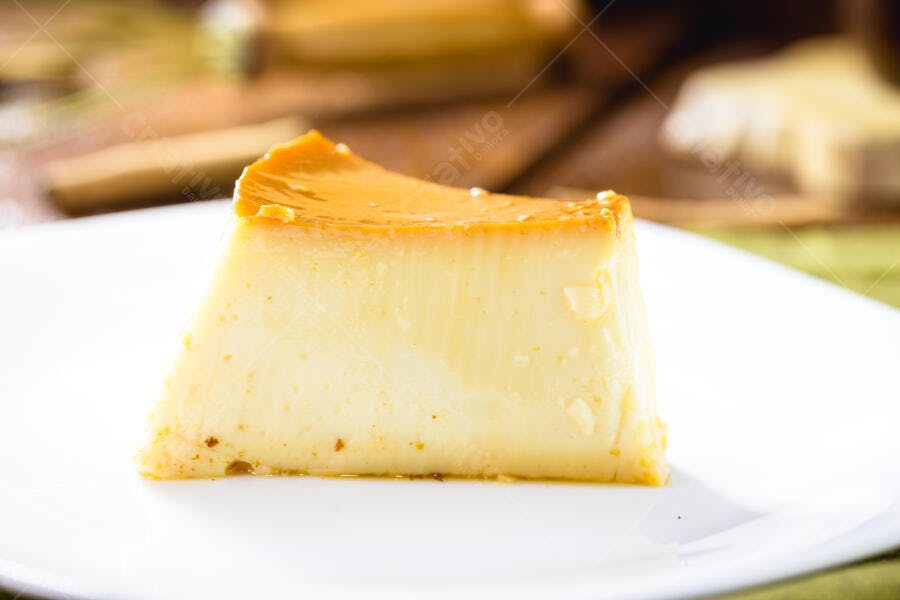 Fatia de pudim de leite condensado com calda de caramelo em prato branco