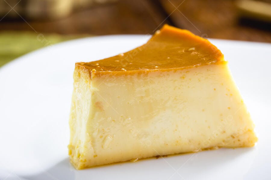 Pudim de leite cremoso com calda de caramelo em prato branco