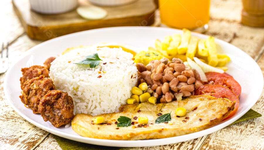 Prato de comida brasileira com frango grelhado arroz feijão batata frita e tomate