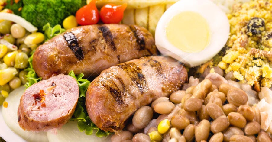 Prato de linguiça grelhada com feijão farofa e ovo cozido refeição brasileira