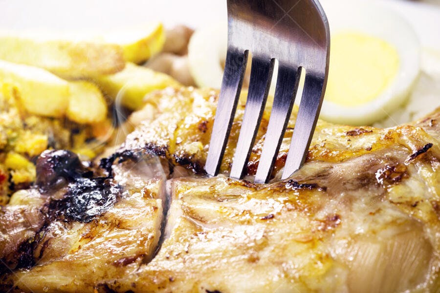 Frango assado suculento com batatas fritas crocantes e ovo cozido sendo pego pelo garfo