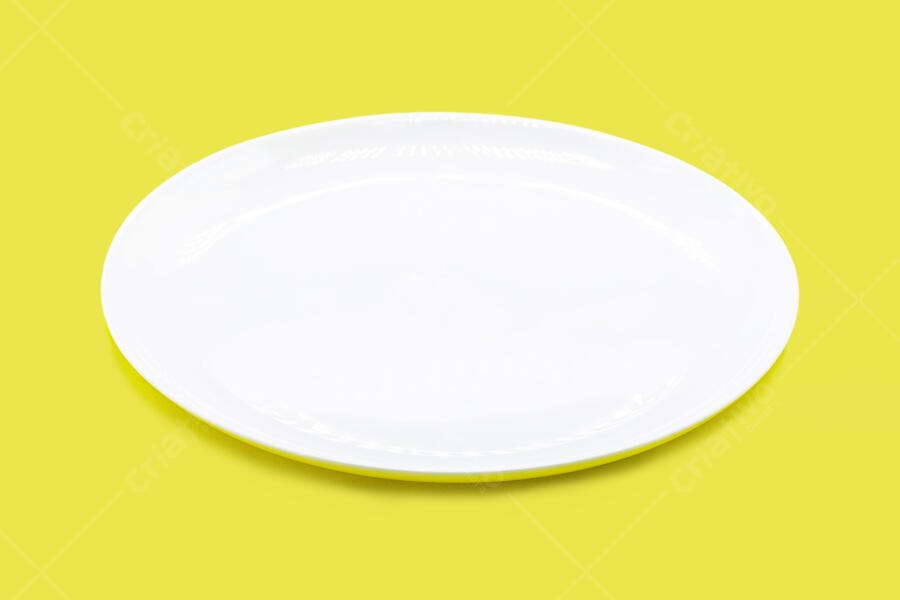 Prato oval branco de cerâmica sobre fundo amarelo vibrante isolado