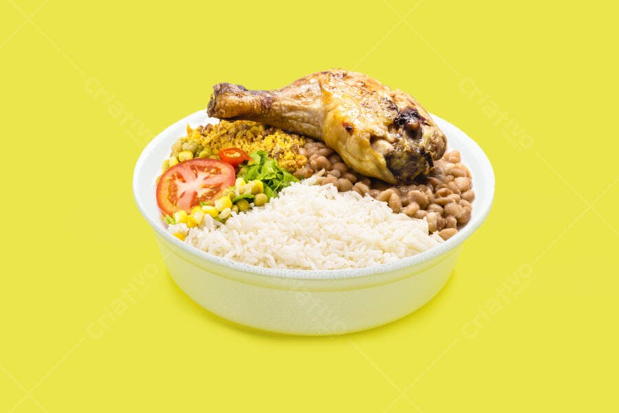 Prato de comida brasileira com coxa de frango assado arroz feijão e salada em fundo amarelo