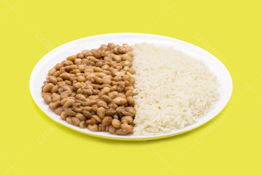 Prato de arroz branco e feijão cozido em fundo amarelo vibrante