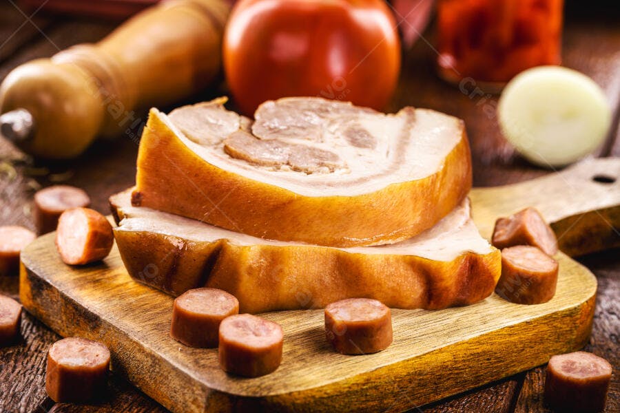 Fatias de barriga de porco defumada com linguiça calabresa na tábua de madeira