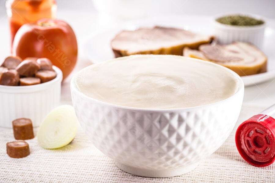 Tigela branca de creme culinário com ingredientes frescos para cozinhar