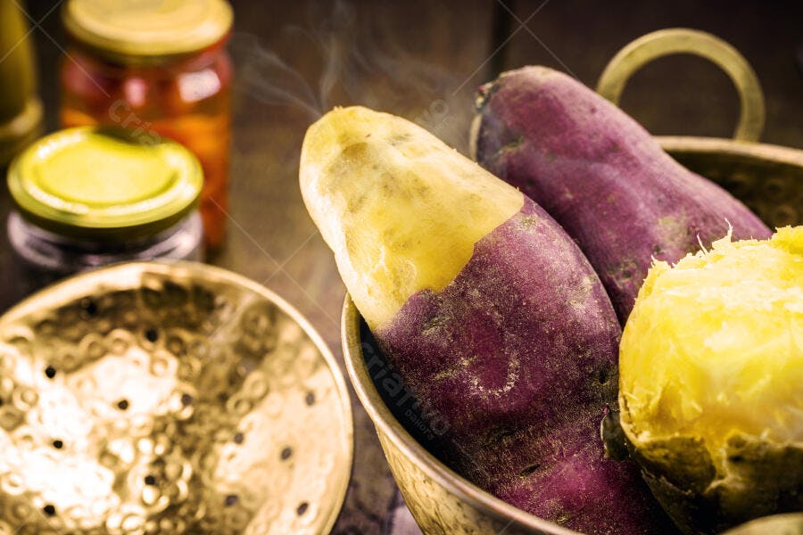 Batata doce roxa e amarela cozida com vapor em tigela rústica
