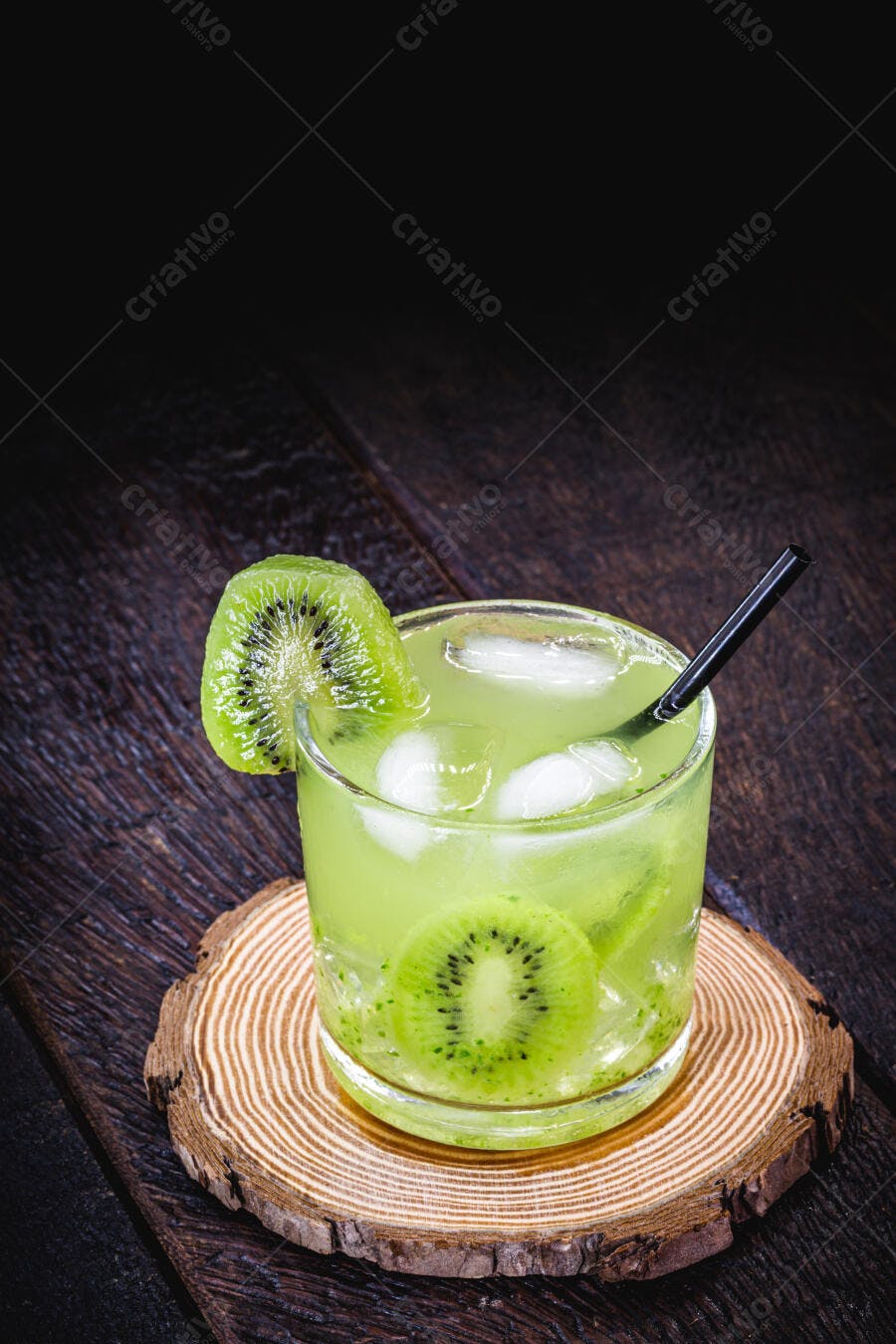 Bebida refrescante de kiwi verde com gelo em copo sobre madeira escura