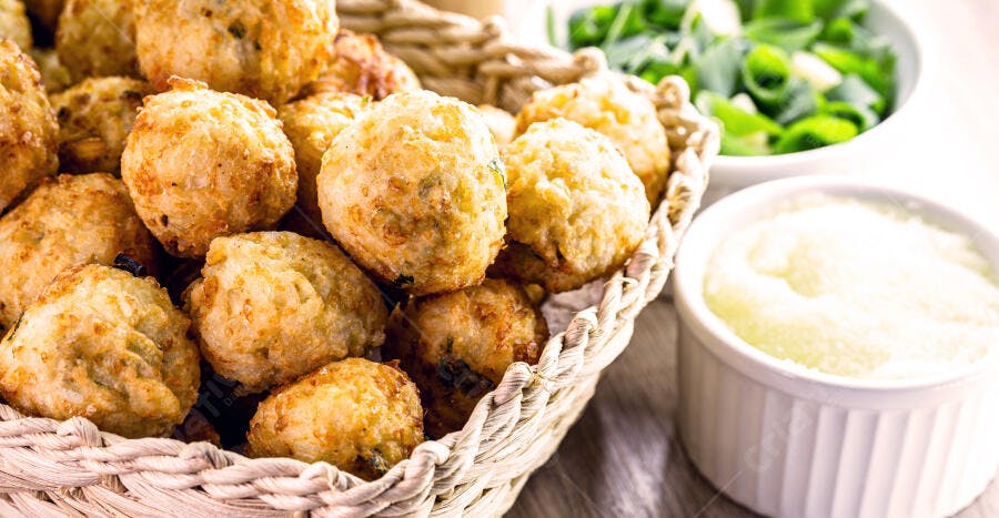 Bolinhos fritos crocantes dourados em cesta molho branco cebolinha