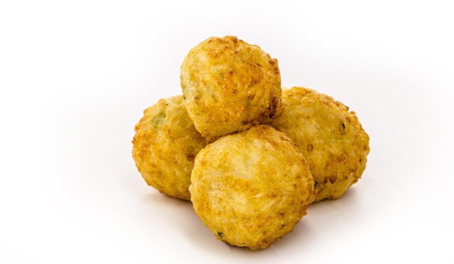 Bolinhos fritos dourados empilhados em fundo branco