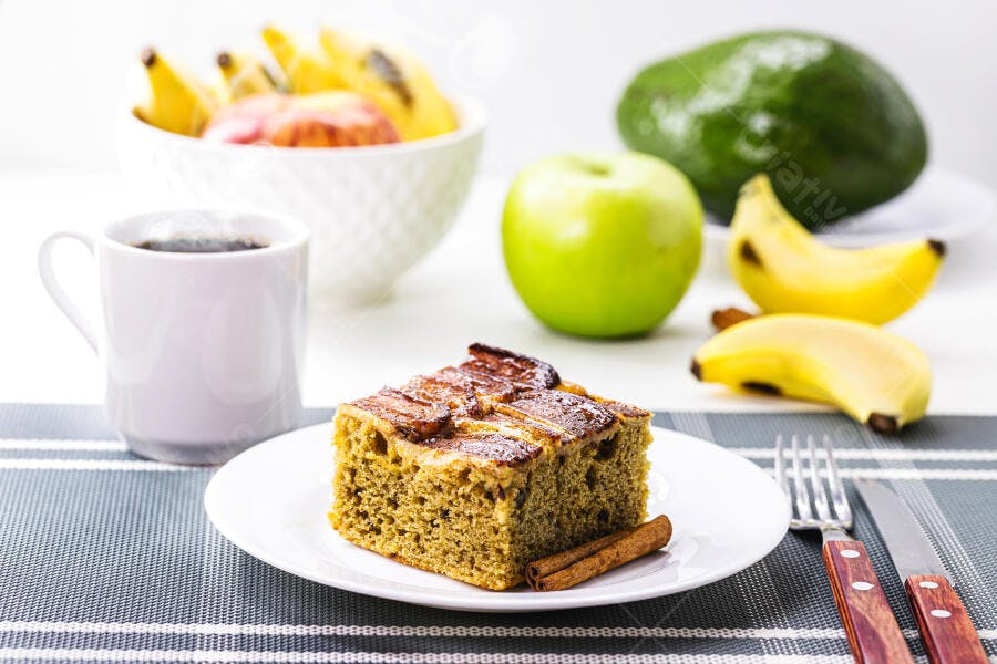 Fatia de bolo de banana com canela, café e frutas frescas para café da manhã