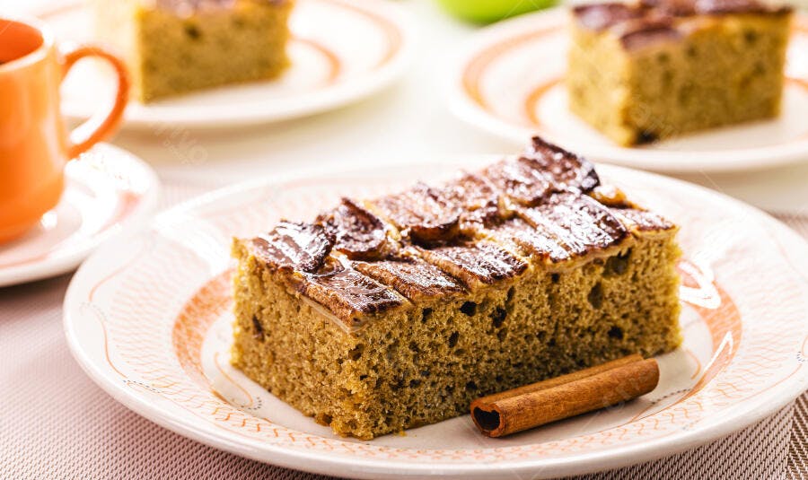 Bolo de maçã verde com canela e açúcar de confeiteiro em prato branco