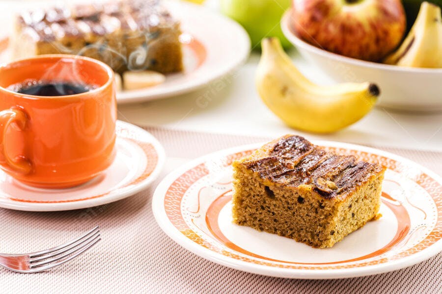Bolo de banana caseiro com café quente na mesa de café da manhã