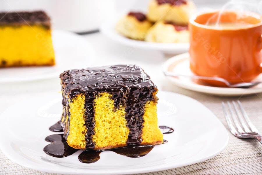 Fatia de bolo de cenoura com calda de chocolate e café quente