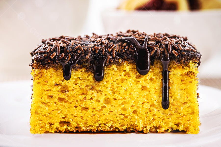 Bolo de cenoura com cobertura de chocolate granulado e calda escorrendo