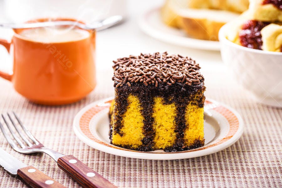 Bolo de fubá com calda de chocolate e granulado no café da manhã amarelo marrom laranja
