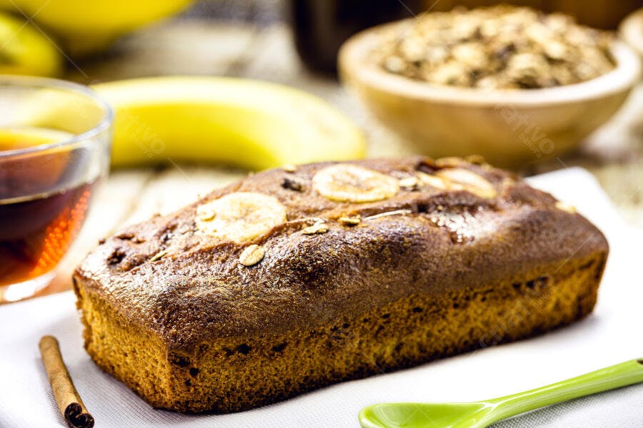 Bolo de banana fresco com aveia e fatias em mesa rústica para café da manhã