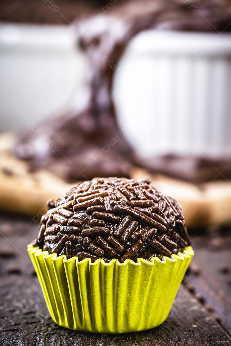 Brigadeiro brasileiro com granulado em forminha amarela sobre madeira escura